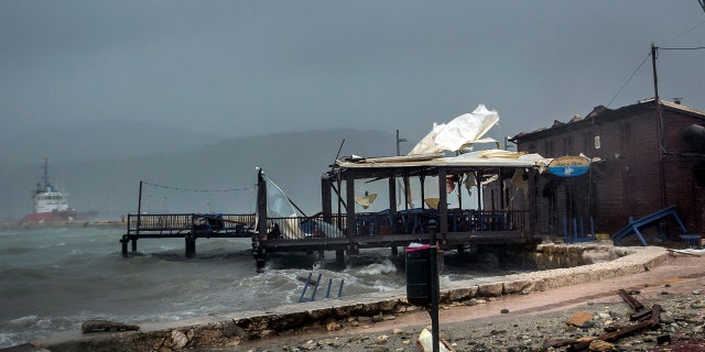 Waves break on a seaside tavern during a storm at the port of Argostoli, on the Ionian island of Kefalonia, western Greece, Friday, Sept. 18, 2020.
