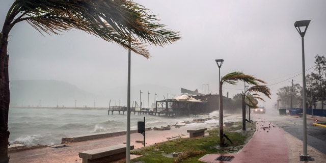 Waves break on a seaside tavern during a storm at the port of Argostoli, on the Ionian island of Kefalonia, western Greece, Friday, Sept. 18, 2020.