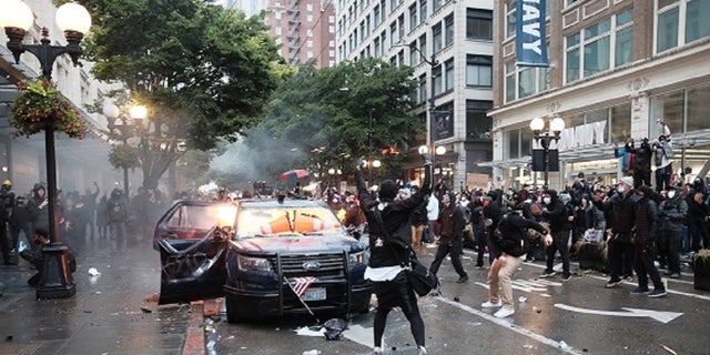 Thomas Kelly Jackson, 20, allegedly threw Molotov cocktails at two Seattle police vehicles during a May 30 protest that devolved into a riot.