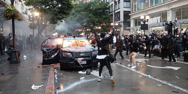 Thomas Kelly Jackson, 20, allegedly threw Molotov cocktails at two Seattle police vehicles during a May 30 protest that devolved into a riot.