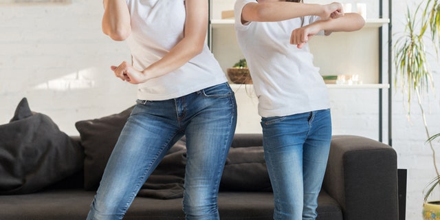 Mom with her daughter dancing in the living room. Kids who are ages 6-12 require 60 minutes of daily physical activity for their hearts, muscles and bones to stay healthy, according to the CDC — and the time can be spread throughout the day.