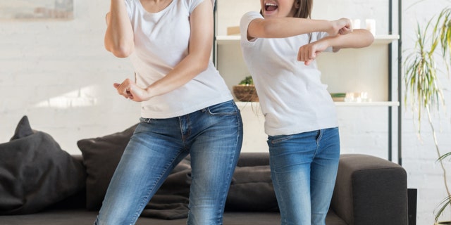 woman and girl dancing together