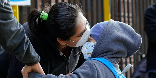 Maria Flores kisses her son Pedro Garcia, 4, while a teacher takes his hand as he arrives for the first day of school at the Mosaic Pre-K Center in the Queens borough of New York, on Sept. 21. (AP)
