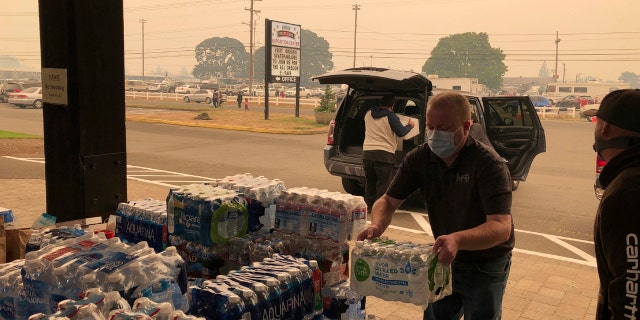 Jonathan Thompson of the Keizer, Oregon, Chamber of Commerce delivers donated bottled water on Tuesday, Sept. 8, 2020, to the Oregon State Fairgrounds in Salem, which is now an evacuation center as wildfires threaten towns in Oregon.