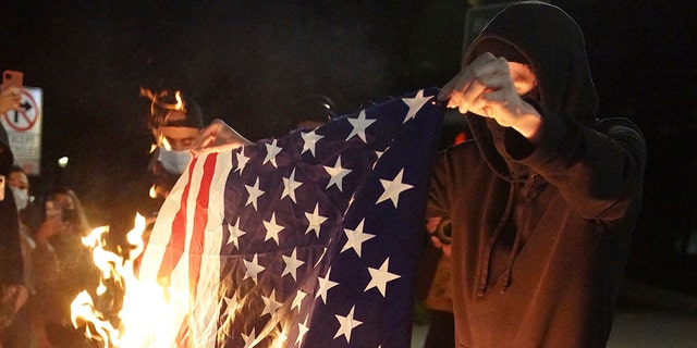A protester burns an American flag while rallying at the Mark O. Hatfield United States Courthouse on Saturday, Sept. 26, 2020, in Portland, Ore. (Associated Press)