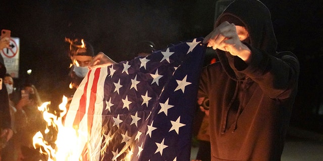 A protester burns an American flag while rallying at the Mark O. Hatfield United States Courthouse on Saturday, Sept. 26, 2020, in Portland, Ore. (Associated Press)