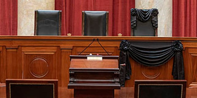 The Courtroom of the Supreme Court showing Associate Justice Ruth Bader Ginsburg’s Bench Chair and the Bench in front of her seat draped in black following her death on September 18th, 2020. (Fred Schilling/US Supreme Court)