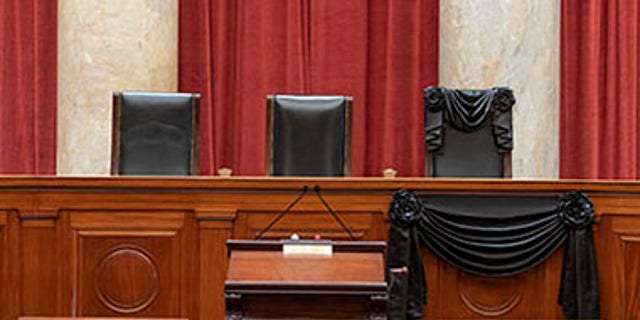 The Courtroom of the Supreme Court showing Associate Justice Ruth Bader Ginsburg’s Bench Chair and the Bench in front of her seat draped in black following her death on September 18th, 2020. (Fred Schilling/US Supreme Court)