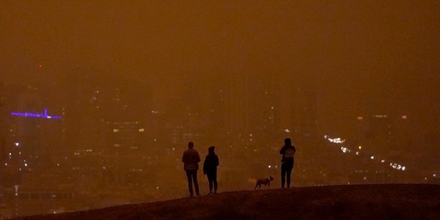 People look toward the skyline obscured by wildfire smoke in daytime from Kite Hill Open Space in San Francisco, Wednesday, Sept. 9, 2020.