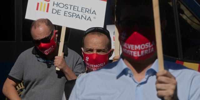 Bar and restaurant owners and workers protest against Covid-19 related restrictions in their sector in Madrid, Spain, Wednesday, Sept. 9, 2020. The Spanish capital, Madrid, has emerged as the most worrying source of new infections and regional authorities had announced new restrictions on social and family gatherings. Signs read 'Spanish hospitality industry'. (AP Photo/Paul White)