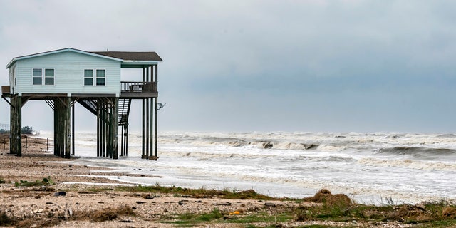 A house sits on the beach on Bolivar Peninsula, Texas, buffeted by the winds and rough surf, Sunday, Sept. 20, 2020.