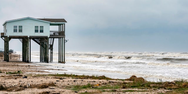 A house sits on the beach on Bolivar Peninsula, Texas, buffeted by the winds and rough surf, Sunday, Sept. 20, 2020.