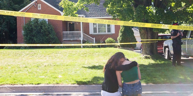 Two women kneel outside the Oshawa, Ontario, house where a shooting left five people dead and one wounded, Sept. 4, 2020. (Getty Images)