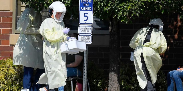 Workers test Utah State University students for COVID-19 on Aug. 30, in Hyde Park, Utah. Students from four dorms were tested and quarantined after the virus was detected in the wastewater from those buildings. (Eli Lucero/The Herald Journal via AP)