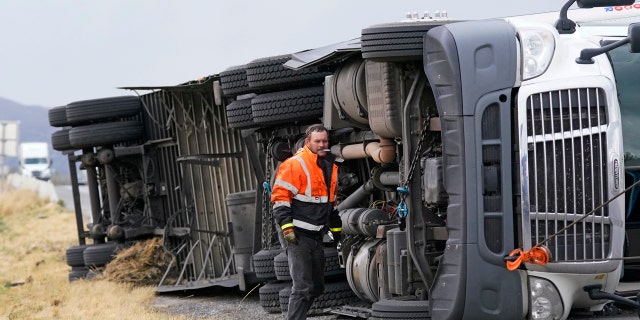 A semi rests on its side after after high winds toppled it on Interstate 15 Tuesday, Sept. 8, 2020, near Bountiful, Utah.