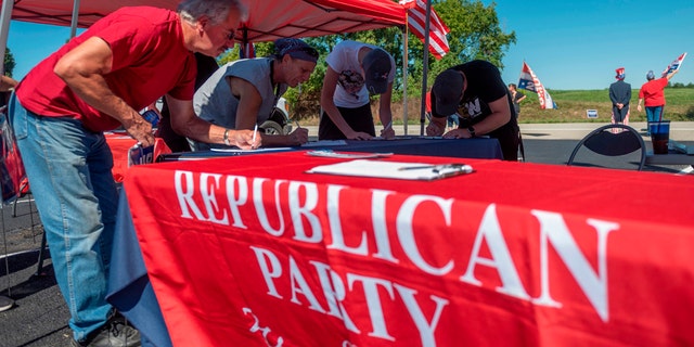 People register to vote during a GOP event in Brownsville, Pa., on Sept. 5, 2020. Less than two months before the Nov. 3 presidential election, the contrast between Republicans and Democrats is striking in Washington County, in the suburbs of Pittsburgh. (Photo by ANDREW CABALLERO-REYNOLDS/AFP via Getty Images)