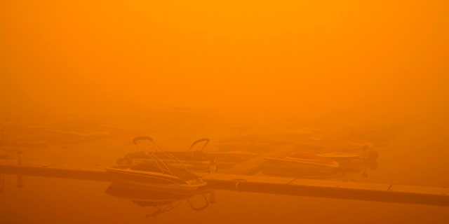 Boats are partially obscured by smoke from a wildfire at a marina on Detroit Lake burned by the Beachie Creek Fire, Saturday, Sept. 12, 2020, in Detroit, Ore.