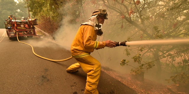 Eagle Field Fire Department firefighter Mark Jones extinguishes hot spots during the Glass Fire in St. Helena, Calif., on Monday, Sept. 28, 2020.