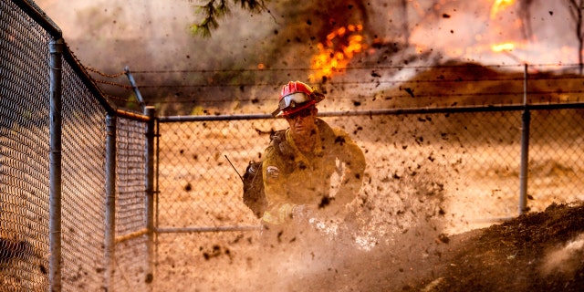 Cal Fire Capt. Jesse Campbell works to save the Louis Stralla Water Treatment Plant as the Glass Fire burns in St. Helena, Calif., on Sunday, Sept. 27, 2020.
