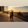 A couple walks along the Malecon at sunset in Havana, Cuba, Aug. 31, 2020. 