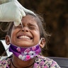 An Indian girl cries as a medical worker collects her swab sample for a COVID-19 test at a rural health center in Bagli, India, Sept. 7, 2020.
