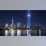 The moon rises between the beams of the Tribute in Light as it is tested over lower Manhattan and One World Trade Center in New York City, Sept. 4, 2020. 