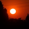 The sun is seen against a sky turned orange with smoke from wildfires as it sets, Tuesday, Sept. 8, 2020, near Sumner, Wash., south of Seattle.