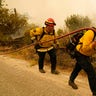 Tim Lesmeister, left, and Rick Archuleta, of the Clovis Fire Department, walk along a road monitoring hotspots left behind by the Creek Fire Tuesday, Sept. 8, 2020, in Tollhouse, Calif.