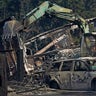 A person uses heavy equipment to put dirt on fire hotspots, Tuesday, Sept. 8, 2020, after a wildfire destroyed homes and outbuildings in Graham, Wash., overnight south of Seattle.