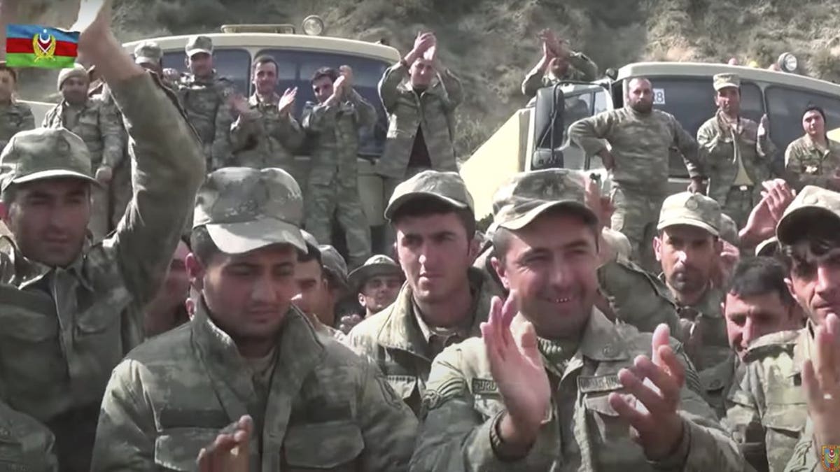 In this grab taken from video released by Azerbaijan's Defense Ministry on Saturday, Oct. 3, 2020, Azerbaijan's solders applaud at a meeting with officers during fighting with forces of the self-proclaimed Republic of Nagorno-Karabakh, Azerbaijan. Armenia and Azerbaijan on Saturday said heavy fighting is continuing in their conflict over the separatist territory of Nagorno-Karabakh. Azerbaijan's president criticized the international mediators who have tried for decades to resolve the dispute. (Azerbaijan's Defense Ministry via AP)