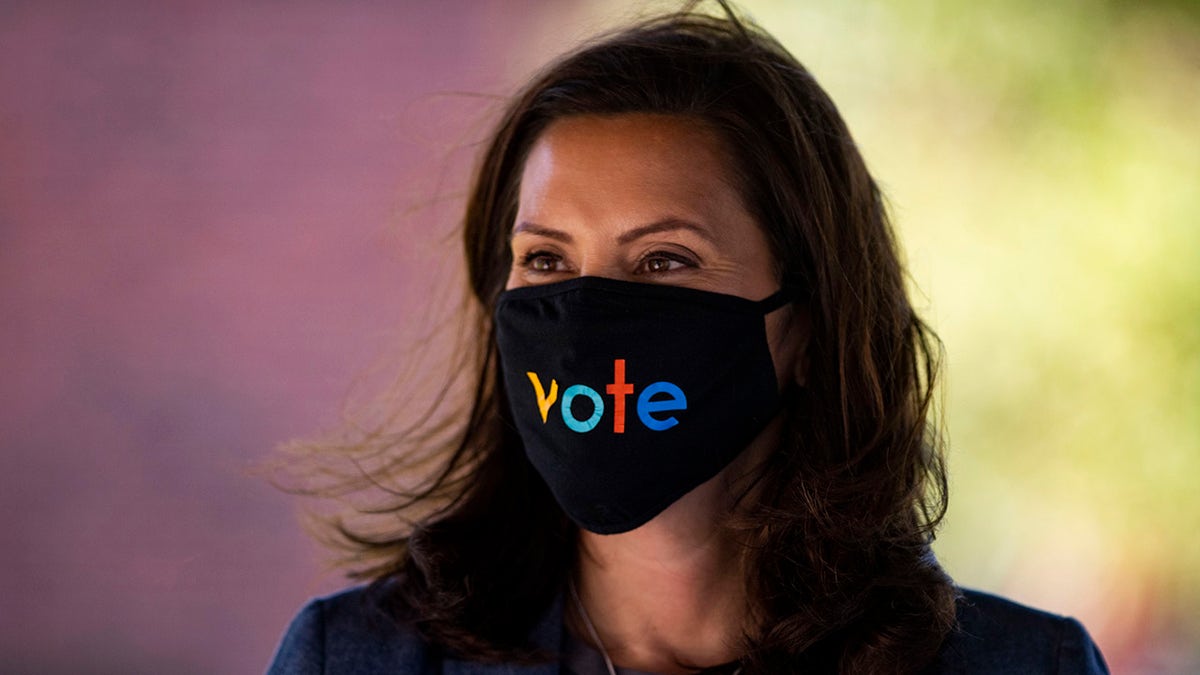 Michigan Gov. Gretchen Whitmer wears a mask with the word "vote" displayed on the front during a roundtable discussion on health care, Wednesday, Oct. 7, 2020, in Kalamazoo, Mich. (Nicole Hester/Ann Arbor News via AP)/