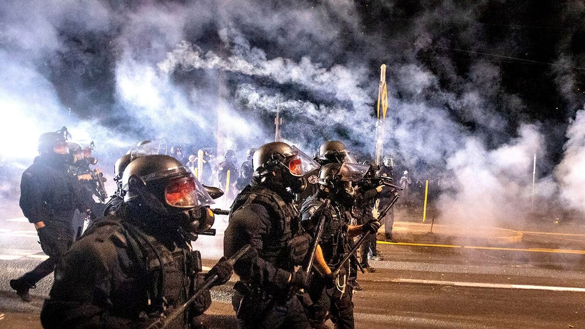 Police use chemical irritants and crowd control munitions to disperse protesters during the 100th consecutive day of demonstrations in Portland, Ore., on Saturday, Sept. 5, 2020. (AP Photo/Noah Berger)