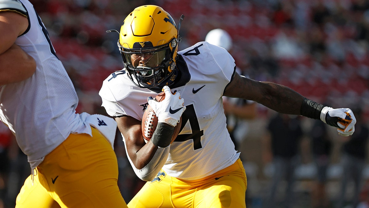 West Virginia's Leddie Brown (4) runs the ball to score a touchdown during the first half of an NCAA college football game against Texas Tech, Saturday, Oct. 24, 2020, in Lubbock, Texas. (AP Photo/Brad Tollefson)
