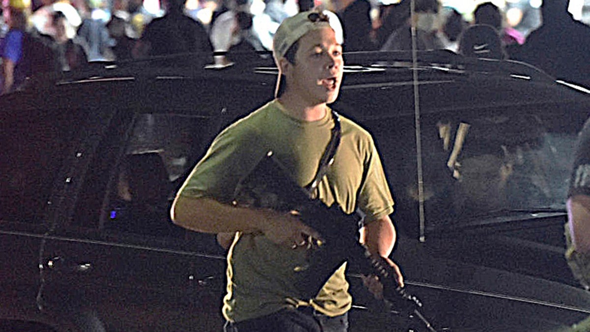 In this Aug. 25, file photo, Kyle Rittenhouse carries a weapon as he walks along Sheridan Road in Kenosha, Wis., during a night of unrest following the weekend police shooting of Jacob Blake. (Adam Rogan/The Journal Times via AP, File)