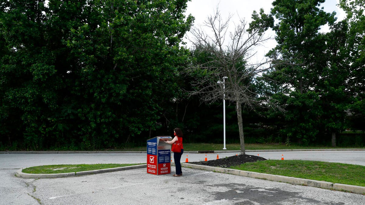 FILE - In this July 1, 2020, file photo, a New Jersey woman drops off her ballot for the New Jersey primary election at a vote-by-mail drop box in a parking lot at Camden County College in Cherry Hill, N.J. Amid the global pandemic, more people than ever are expected to bypass their polling place and cast absentee ballots for the first time. Voters marking ballots from home could lead to an increase in the kinds of mistakes that typically would be caught by a scanner or election worker at the polls. (AP Photo/Matt Slocum, File)