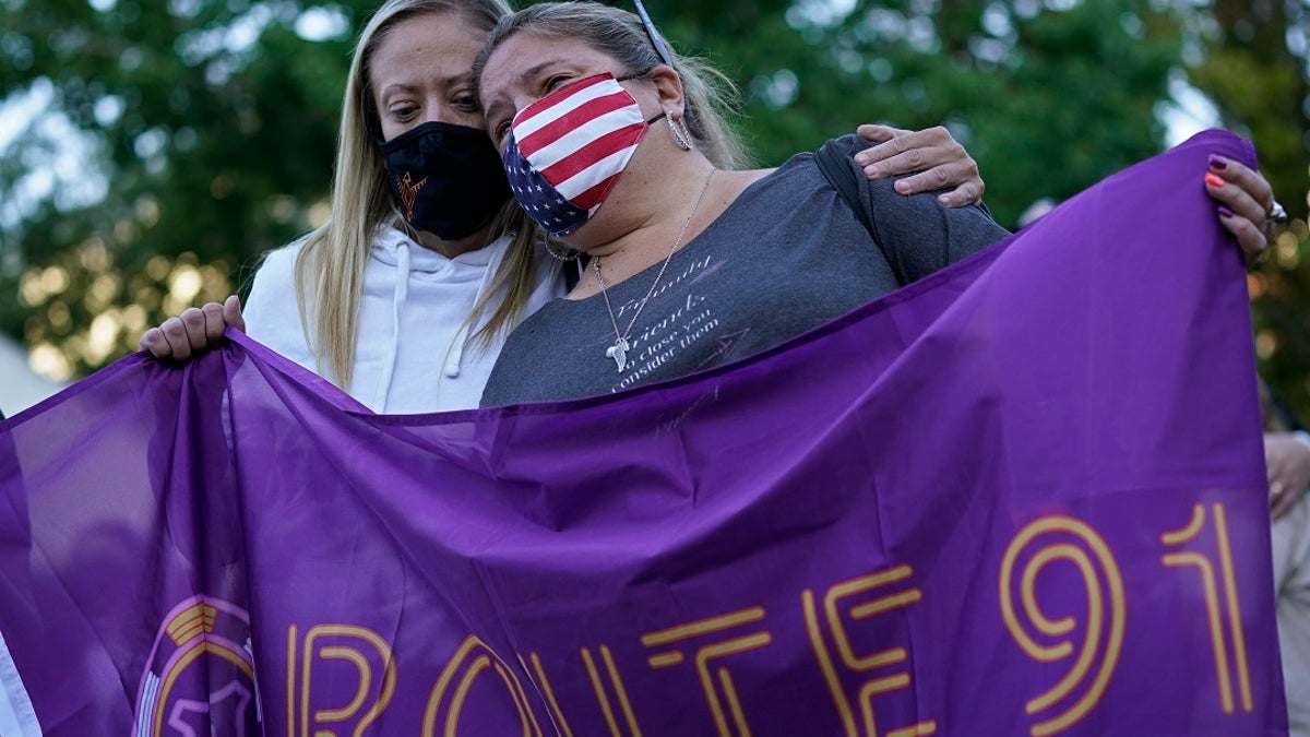 Sarah Lamers, left, comforts Jill Winters during a ceremony Thursday on the anniversary of the mass shooting three years earlier in Las Vegas. The ceremony was held for survivors and victim's families of the deadliest mass shooting in modern U.S. history. Officials updated the death toll from 58 to 60 after two women died within the last year from injures sustained during the shooting. (AP Photo/John Locher)