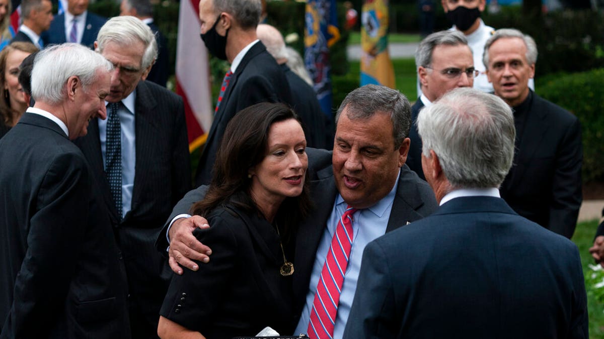 In this Saturday, Sept. 26, 2020, photo former New Jersey Gov. Chris Christie, front second from right, speaks with others after SCOTUS nomination. Notre Dame President Father John Jenkins stands at back right. (AP Photo/Alex Brandon)