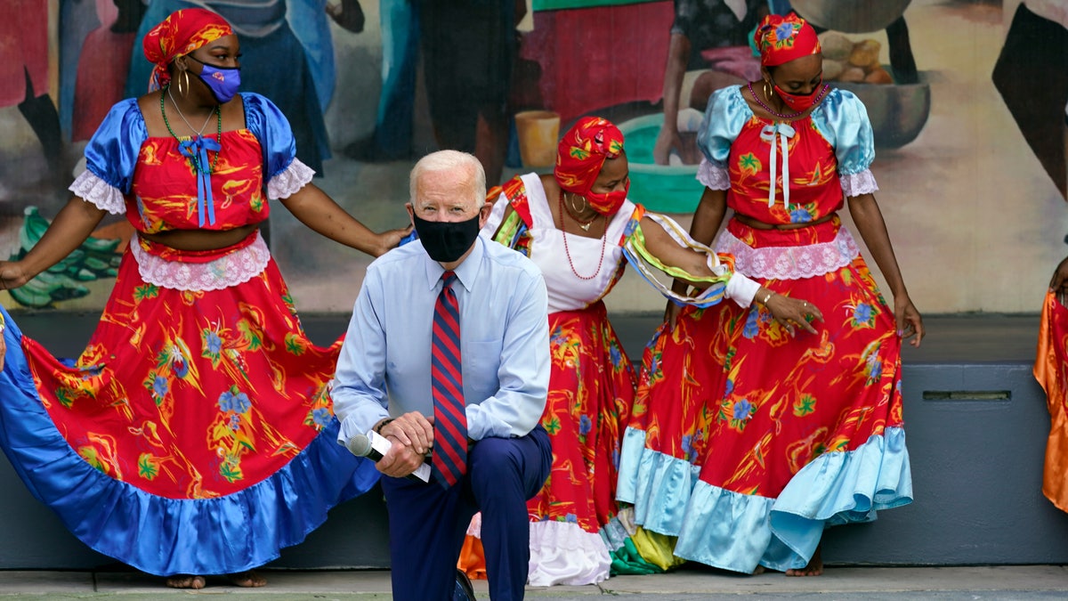 Democratic presidential candidate former Vice President Joe Biden poses fora. Photo with dancers as he visits Little Haiti Cultural Complex, Monday, Oct. 5, 2020, in Miami. (AP Photo/Andrew Harnik)