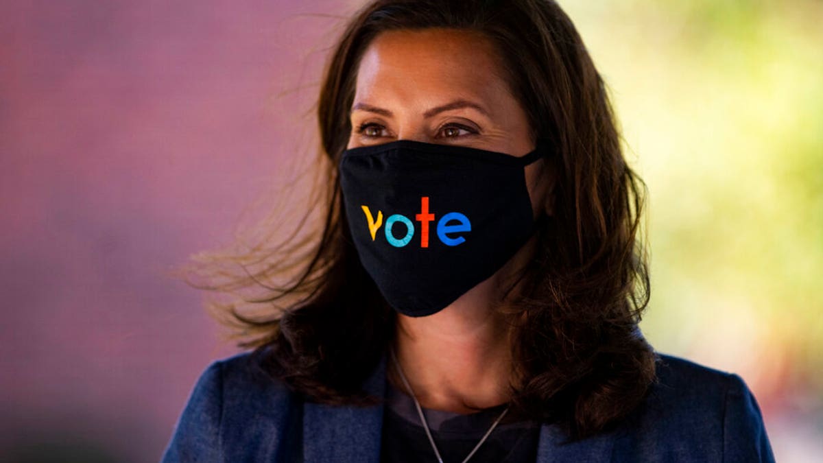 Michigan Gov. Gretchen Whitmer wears a mask with the word "vote" displayed on the front during a roundtable discussion on healthcare, Wednesday Oct. 7, 2020, in Kalamazoo, Mich. (Nicole Hester/Ann Arbor News via AP)/