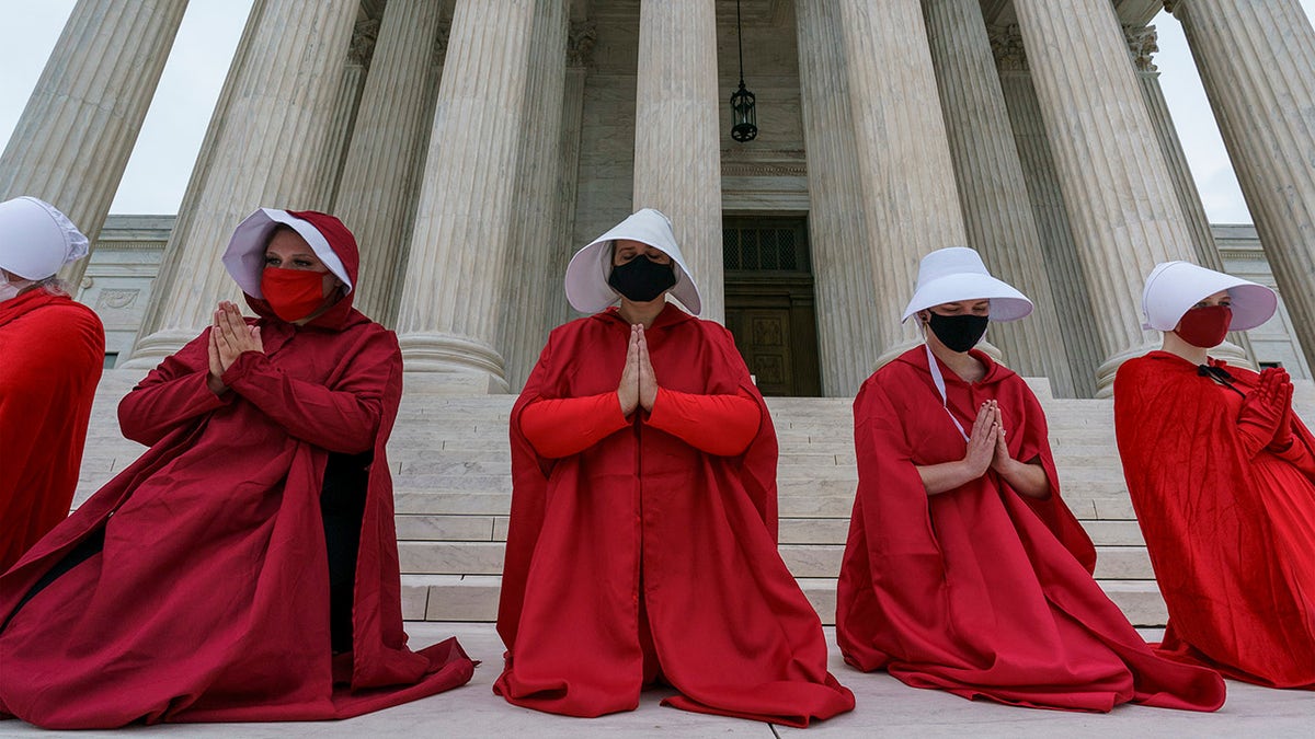 Activists opposed to the confirmation of President Donald Trump's Supreme Court nominee, Judge Amy Coney Barrett, are dressed as characters from "The Handmaid's Tale," at the Supreme Court on Capitol Hill in Washington, Sunday, Oct. 11, 2020. Barrett's confirmation hearing begins Monday before the Republican-led Senate Judiciary Committee. (AP Photo/J. Scott Applewhite)