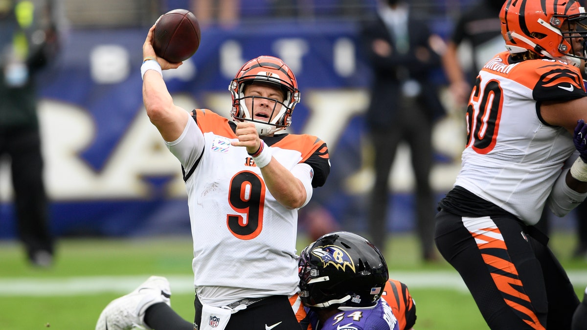 Baltimore Ravens linebacker Tyus Bowser, back, makes a hit on Cincinnati Bengals quarterback Joe Burrow as he tries a pass during the first half of an NFL football game, Sunday, Oct. 11, 2020, in Baltimore. (AP Photo/Nick Wass)