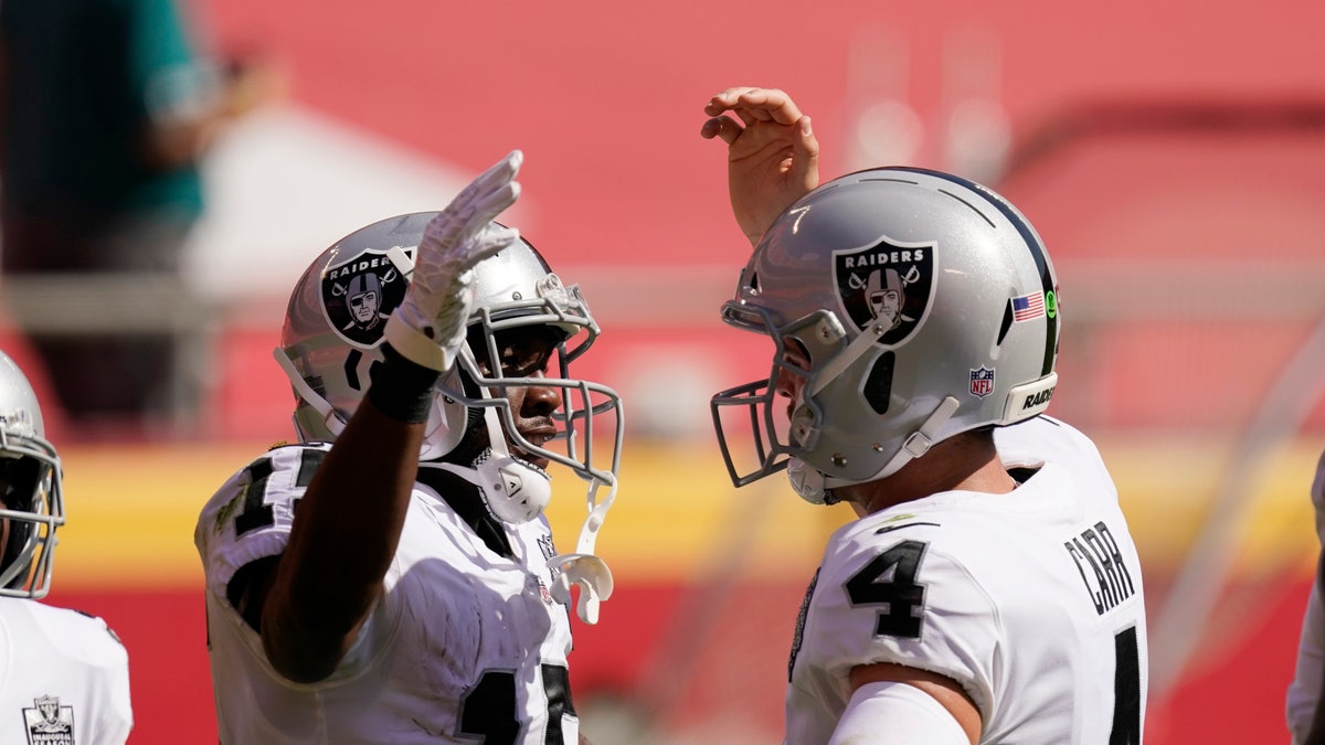 Las Vegas Raiders wide receiver Nelson Agholor, left, celebrates with quarterback Derek Carr after catching a 59-yard touchdown pass during the first half of a game against the Kansas City Chiefs, Sunday, Oct. 11, 2020, in Kansas City.