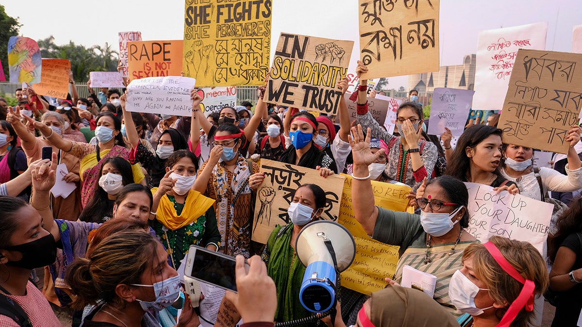 Women’s rights activists and others protesting against gender-based violence hold placards outside the Parliament in Dhaka, Bangladesh, Friday, Oct.9, 2020. Bangladesh's Cabinet has approved an increase in the maximum punishment in rape cases to death from life imprisonment after a series of recent sexual assaults triggered protests. (AP Photo/ Mahmud Hossain Opu)