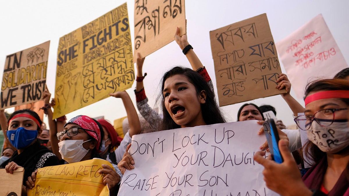 Women’s rights activists and others protesting against gender-based violence hold placards outside the Parliament in Dhaka, Bangladesh, Friday, Oct.9, 2020. Bangladesh's Cabinet has approved an increase in the maximum punishment in rape cases to death from life imprisonment after a series of recent sexual assaults triggered protests. (AP Photo/ Mahmud Hossain Opu)