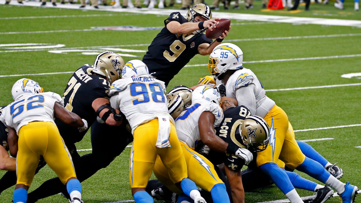 New Orleans Saints quarterback Drew Brees (9) dives over the goal line for a touchdown in the first half of an NFL football game against the Los Angeles Chargers in New Orleans, Monday, Oct. 12, 2020. (AP Photo/Butch Dill)