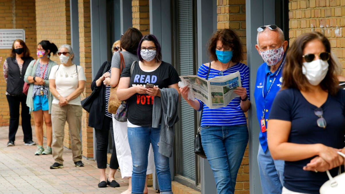 In this Sept. 18 photo, Alexandria residents wait in a socially distance line to cast their ballots for the November presidential election on first day of early voting in Virginia, at the Voter Registration Office in Alexandria, Va. (John McDonnell/The Washington Post via AP, File)