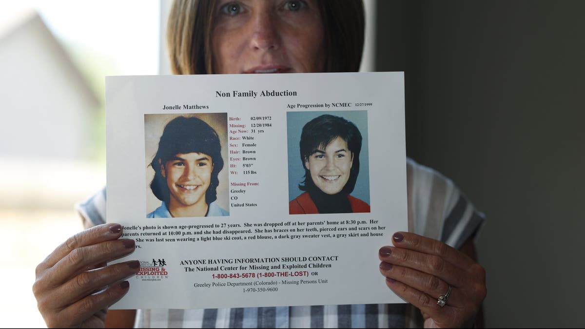 Jonelle Matthews sister holding a photo of her sibling.