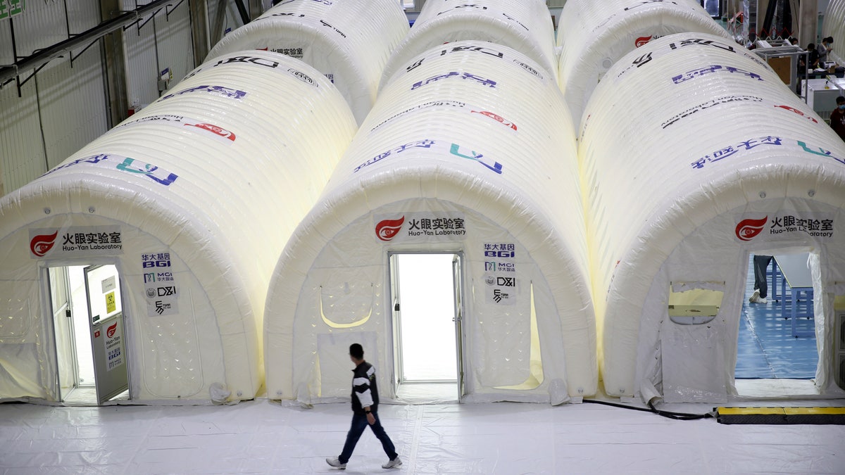 A man walks past temporary COVID-19 test processing labs set up inside inflatable tents in Qingdao in eastern China's Shandong Province, Oct. 14.? (Chinatopix via AP)
