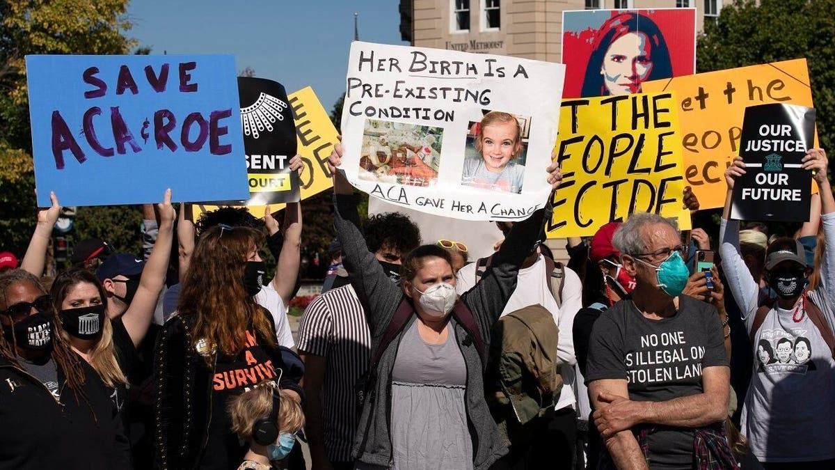 Protesters opposed to the confirmation of President Donald Trump's Supreme Court nominee Amy Coney Barrett, rally at the Supreme Court on Capitol Hill, in Washington, Wednesday, Oct. 14, 2020. (AP Photo/Jose Luis Magana)