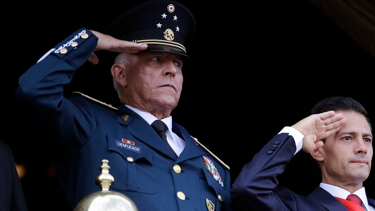 FILE - In this Sept. 16, 2016 file photo, Defense Secretary Gen. Salvador Cienfuegos, left, and Mexico's President Enrique Pena Nieto, salute during the annual Independence Day military parade in Mexico City's main square. Mexico's top diplomat says the country's former defense secretary, Gen. Salvador Cienfuegos, has been arrested in Los Angeles. Foreign Relations Secretary Marcelo Ebrard wrote Thursday, Oct. 15, 2020 in his Twitter account that U.S. Ambassador Christopher Landau had informed him of Cienfuegos' arrest. (AP Photo/Rebecca Blackwell, File)